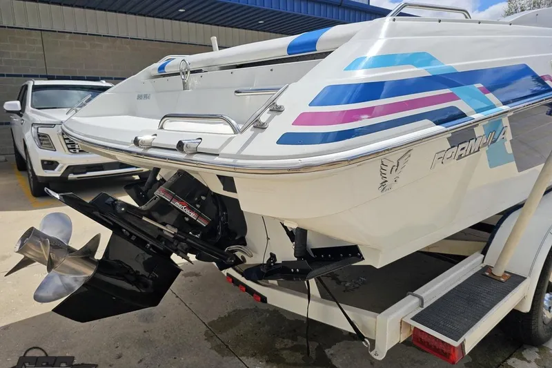 Slide: The Image of 1997 Formula 252 SS boat with colorful graphics, displayed on a trailer in a parking area. - 31