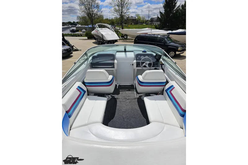 Slide: The Image of 1997 Formula 252 SS boat interior with white and striped seating, parked outdoors. - 44