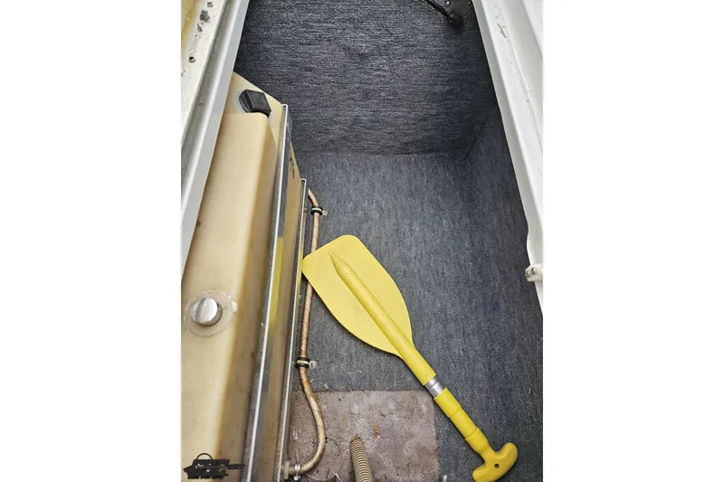 Slide: The Image of Interior of a 1997 Formula 252 SS boat with a yellow paddle and storage compartment. - 59