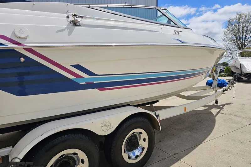 Slide: The Image of 1997 Formula 252 SS boat on trailer with colorful stripes, parked outdoors. - 6