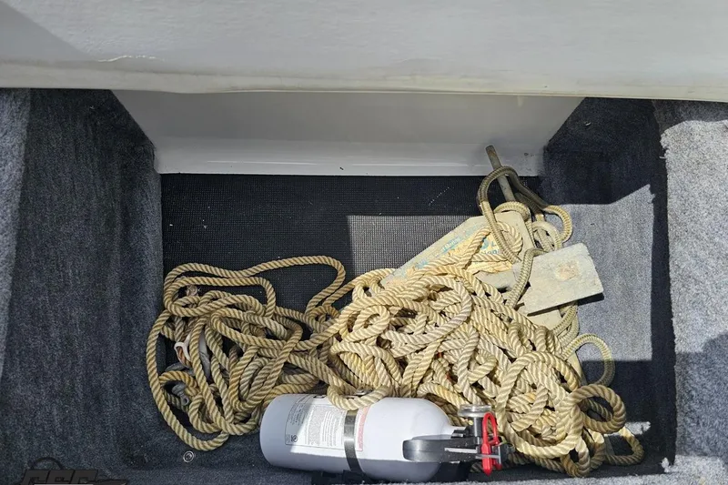 Slide: The Image of Storage compartment of a 1997 Formula 252 SS boat with rope and fire extinguisher. - 91