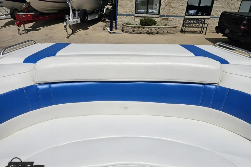 Slide: The Image of White and blue seating on a 1997 Formula 252 SS boat, parked outdoors. - 94