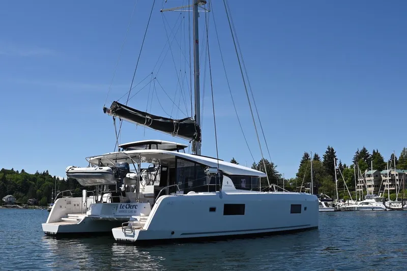 Slide: The Image of 2022 Lagoon 42 catamaran anchored in a scenic marina setting. - 3