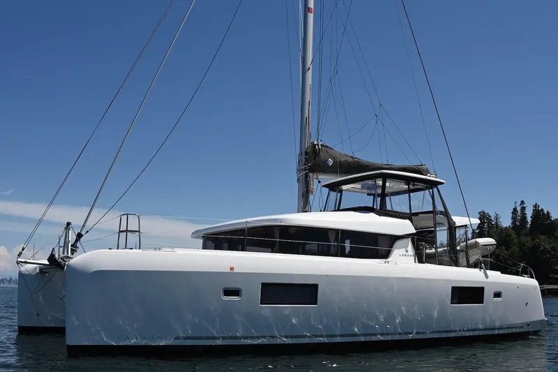 Slide: The Image of 2022 Lagoon 42 catamaran sailing on calm waters under a clear blue sky. - 6