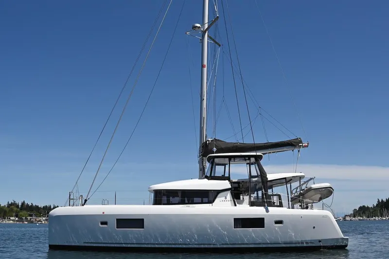 Slide: The Image of 2022 Lagoon 42 catamaran sailing on calm waters under a clear blue sky. - 7