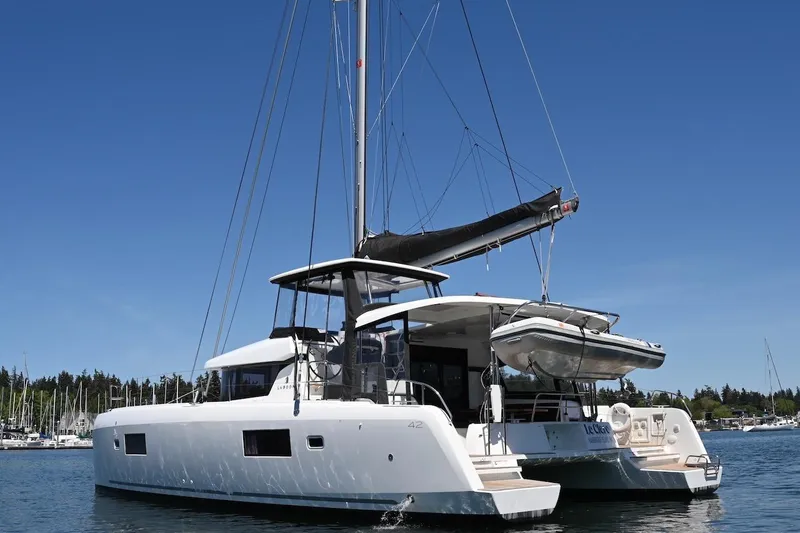 Slide: The Image of 2022 Lagoon 42 catamaran sailing on a clear day in a marina. - 8