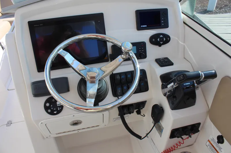 Slide: The Image of 2017 Sailfish 275 DC boat dashboard with steering wheel and control panel. - 14