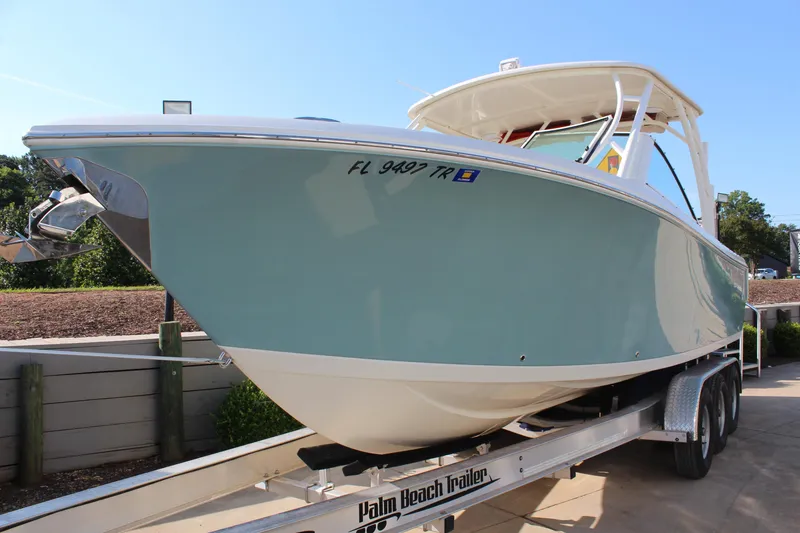 Slide: The Image of 2017 Sailfish 275 DC boat on trailer, side view, light blue hull. - 7