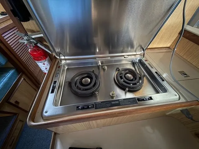 Slide: The Image of 1984 Bertram 30 kitchen area with two-burner stove. - 11