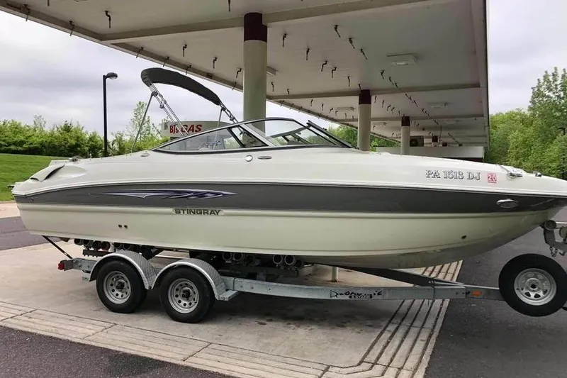 Slide: The Image of 2011 Stingray 235 LR boat on trailer under canopy, side view. - 1