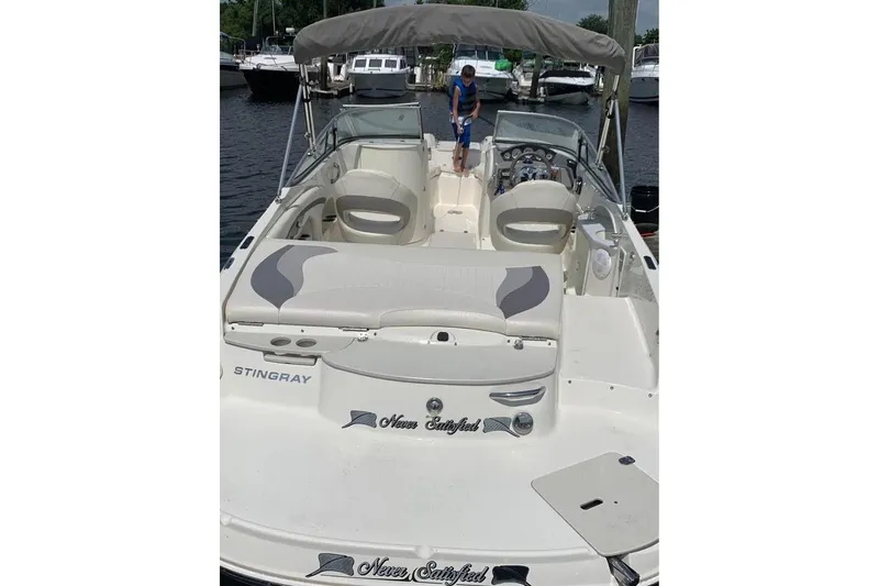 Slide: The Image of 2011 Stingray 235 LR boat with seating, docked at a marina. - 3