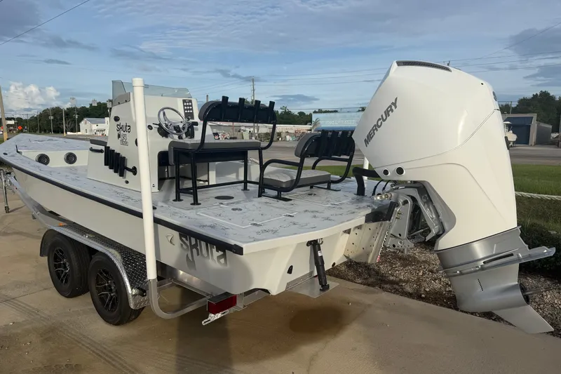 Slide: The Image of 2026 Skuta Vista 24 boat with Mercury engine on trailer, parked outdoors. - 5