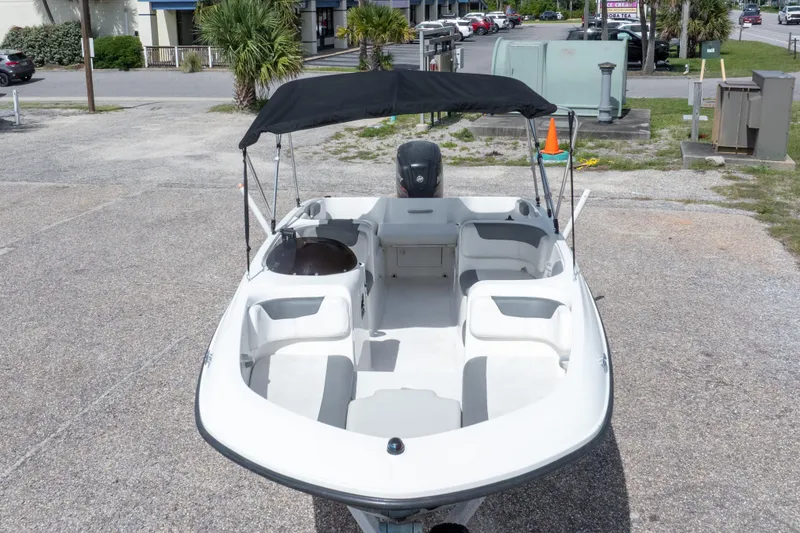 Slide: The Image of 2015 Bayliner Element XL boat with canopy, parked on gravel lot. - 10