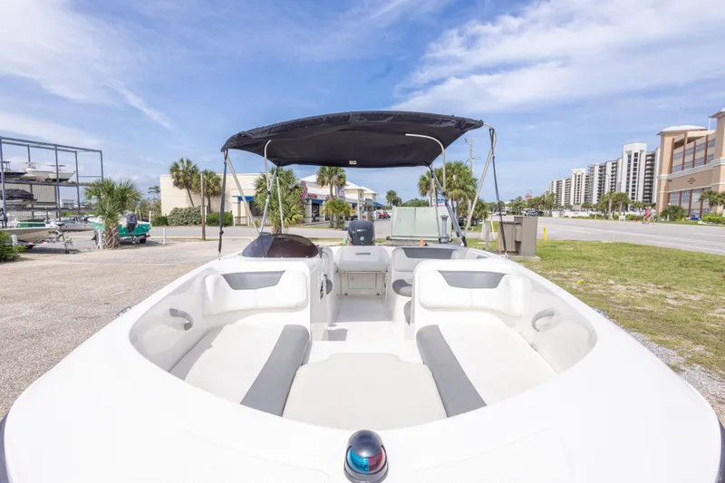 Slide: The Image of 2015 Bayliner Element XL boat with canopy, parked near buildings and palm trees. - 16