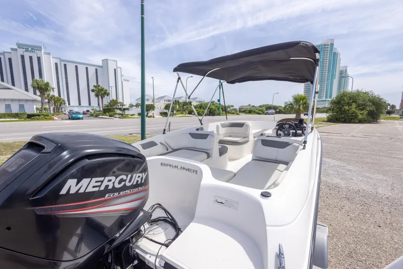 Slide: The Image of 2015 Bayliner Element XL boat with Mercury engine, parked near modern buildings. - 17