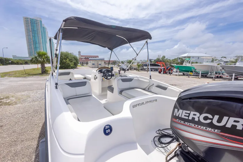 Slide: The Image of 2015 Bayliner Element XL boat with Mercury FourStroke engine, parked near a marina. - 18