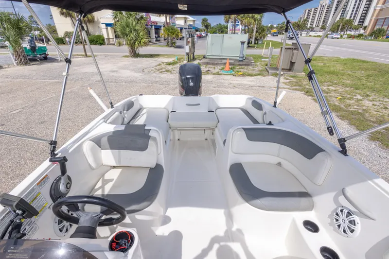 Slide: The Image of 2015 Bayliner Element XL boat interior with seating and steering wheel, parked outdoors. - 22