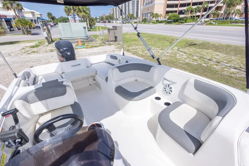 Slide: The Image of 2015 Bayliner Element XL boat interior with seating and steering wheel, parked near a road. - 28