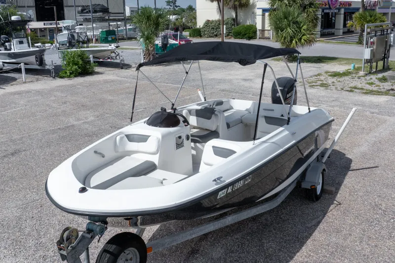 Slide: The Image of 2015 Bayliner Element XL boat on trailer, parked outdoors with canopy. - 3