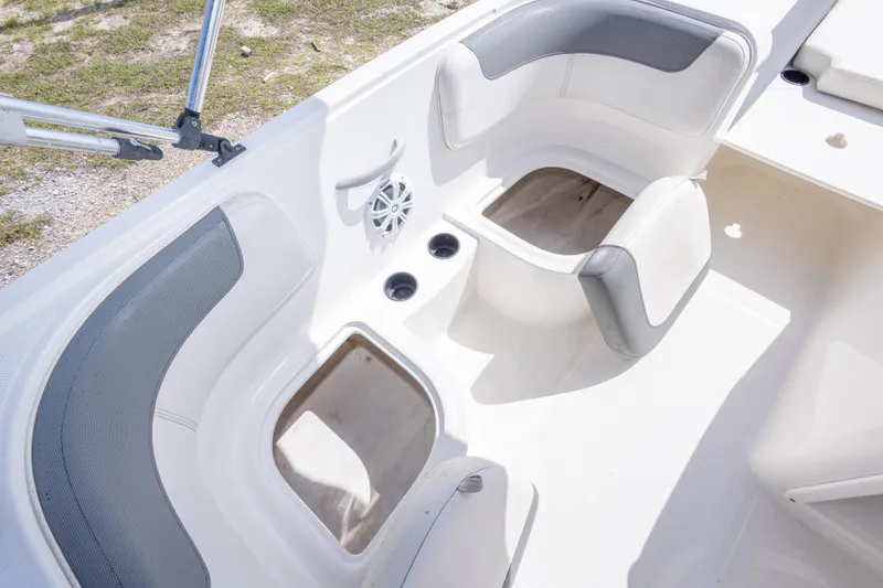 Slide: The Image of 2015 Bayliner Element XL boat interior with white seating and storage compartments. - 32