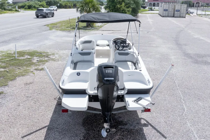 Slide: The Image of 2015 Bayliner Element XL boat with canopy, parked on gravel near a road. - 37