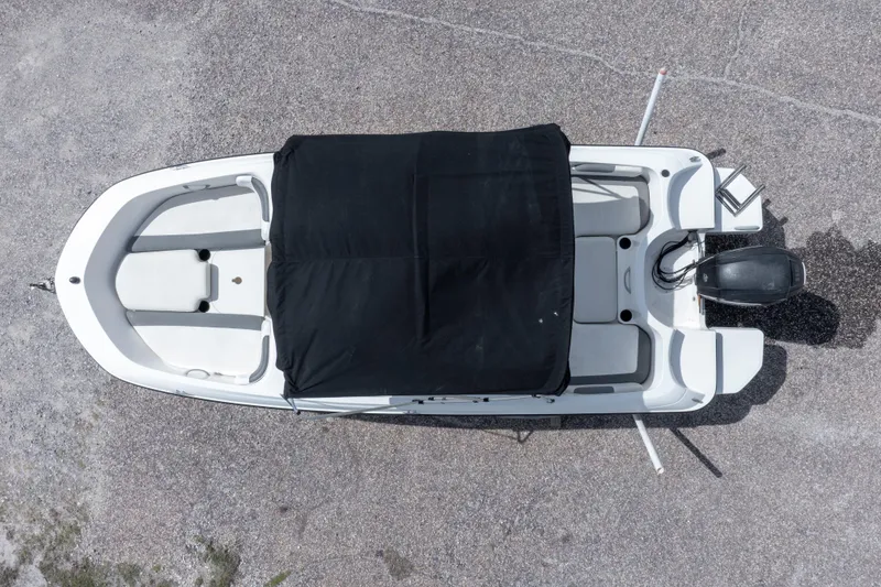 Slide: The Image of 2015 Bayliner Element XL boat, aerial view with black cover, parked on concrete surface. - 6