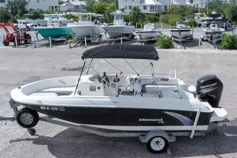 Slide: The Image of 2015 Bayliner Element XL boat with Mercury engine on trailer in marina setting. - 9