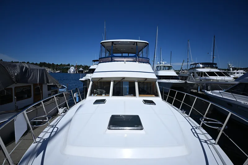 Slide: The Image of 1999 McKinna 47 Sedan yacht docked at marina under clear blue sky. - 12