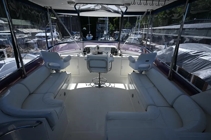 Slide: The Image of Interior of a 1999 McKinna 47 Sedan yacht with white seating and helm station. - 15
