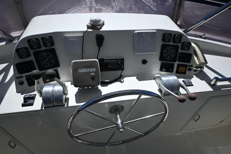 Slide: The Image of 1999 McKinna 47 Sedan helm with Garmin navigation and dual throttle controls. - 16
