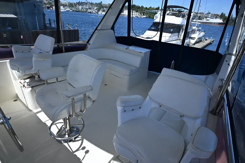 Slide: The Image of Interior of 1999 McKinna 47 Sedan yacht with white seating and waterfront view. - 17