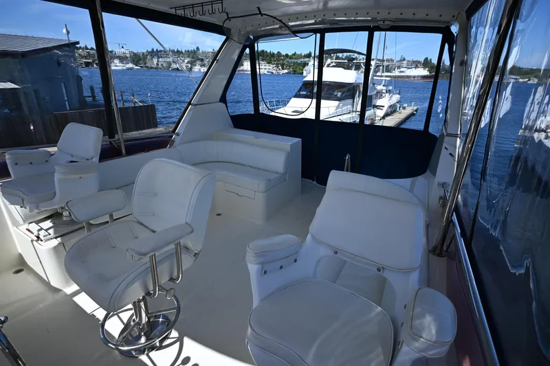Slide: The Image of Interior of 1999 McKinna 47 Sedan yacht with white seating and marina view. - 19