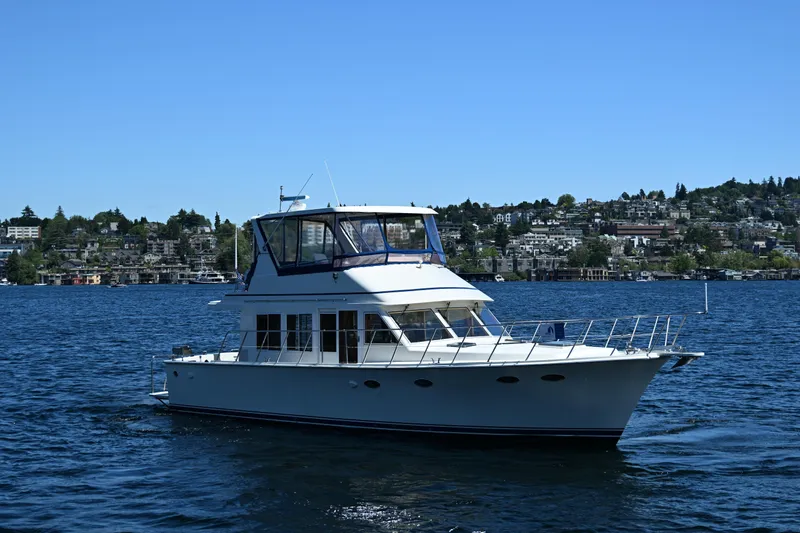 Slide: The Image of 1999 McKinna 47 Sedan yacht cruising on a scenic lake. - 2