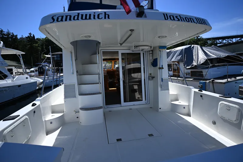 Slide: The Image of 1999 McKinna 47 Sedan yacht docked, featuring spacious deck and sliding glass doors. - 23