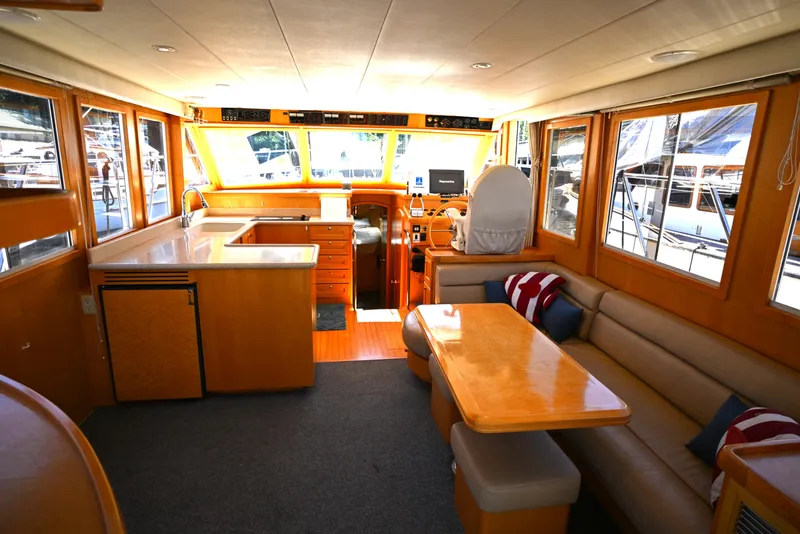 Slide: The Image of Interior of a 1999 McKinna 47 Sedan yacht with seating and helm. - 25