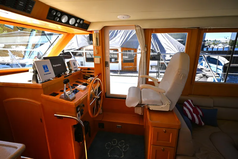 Slide: The Image of Interior of a 1999 McKinna 47 Sedan yacht with helm station and captain's chair. - 28