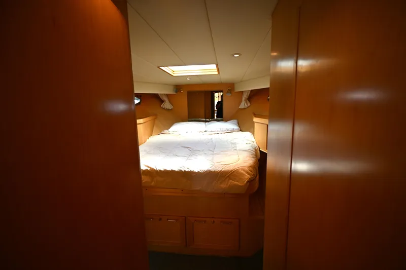 Slide: The Image of Interior cabin of a 1999 McKinna 47 Sedan yacht with cozy bed and wooden finish. - 33