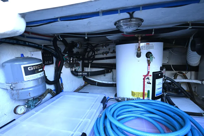 Slide: The Image of Engine room of a 1999 McKinna 47 Sedan yacht with equipment and hoses. - 44
