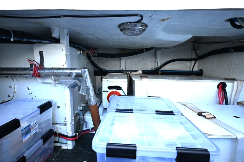 Slide: The Image of Storage compartment of a 1999 McKinna 47 Sedan with organized plastic containers. - 45