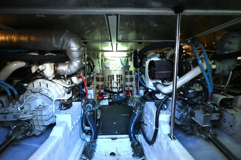 Slide: The Image of Engine room of a 1999 McKinna 47 Sedan yacht, showcasing complex machinery and piping. - 49