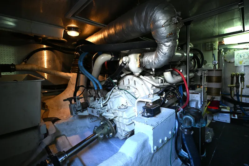 Slide: The Image of Engine room of a 1999 McKinna 47 Sedan yacht, showcasing complex machinery. - 50