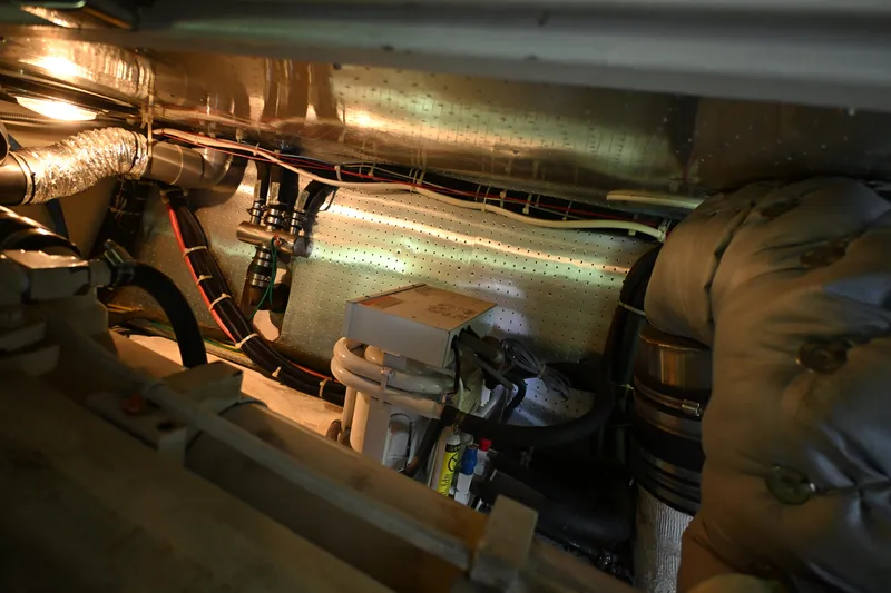Slide: The Image of Engine room of a 1999 McKinna 47 Sedan yacht, showcasing pipes and insulation. - 55
