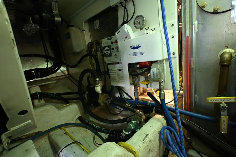 Slide: The Image of Engine room of a 1999 McKinna 47 Sedan with various mechanical components and wiring. - 57