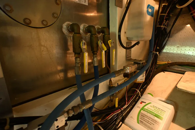 Slide: The Image of Engine room of a 1999 McKinna 47 Sedan with pipes and wiring. - 59