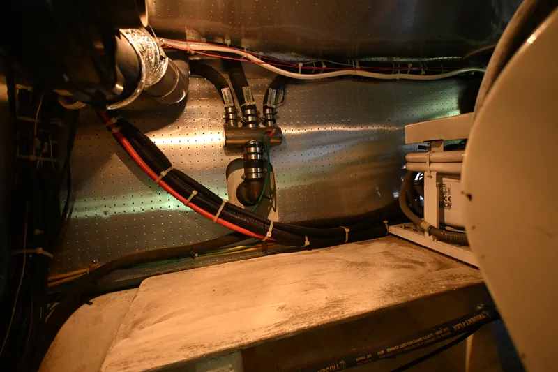 Slide: The Image of Engine room of a 1999 McKinna 47 Sedan yacht, showcasing wiring and components. - 60