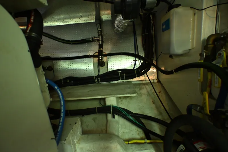 Slide: The Image of Engine room of a 1999 McKinna 47 Sedan with visible hoses and components. - 62