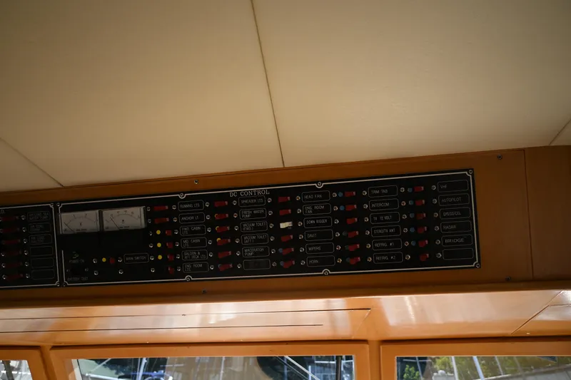 Slide: The Image of Control panel of a 1999 McKinna 47 Sedan yacht, featuring various switches and indicators. - 68