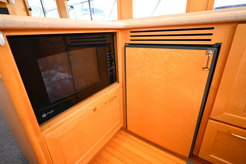 Slide: The Image of 1999 McKinna 47 Sedan yacht kitchen with microwave and Norcold refrigerator. - 72