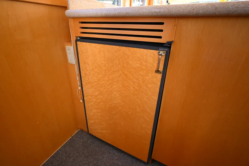 Slide: The Image of Norcold refrigerator in 1999 McKinna 47 Sedan yacht interior, featuring wood paneling. - 73