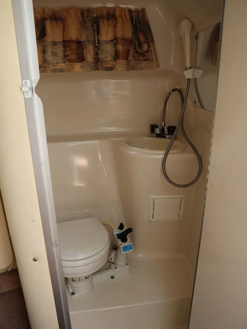 Slide: The Image of Interior of a 1998 Monterey 242 Cruiser with toilet and sink. - 14